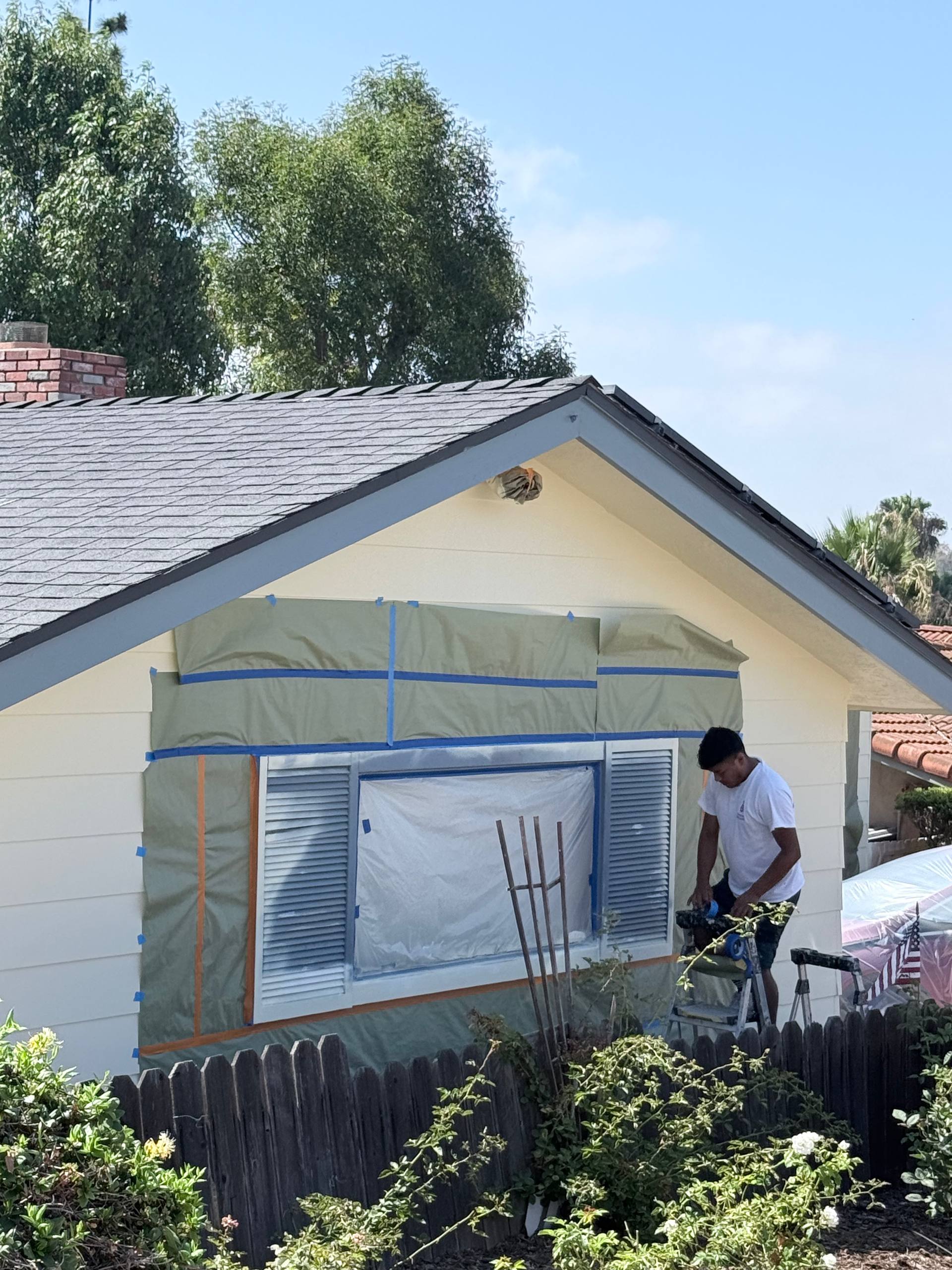 Painter prepping window before exterior painting, Rancho Santa Margarita CA