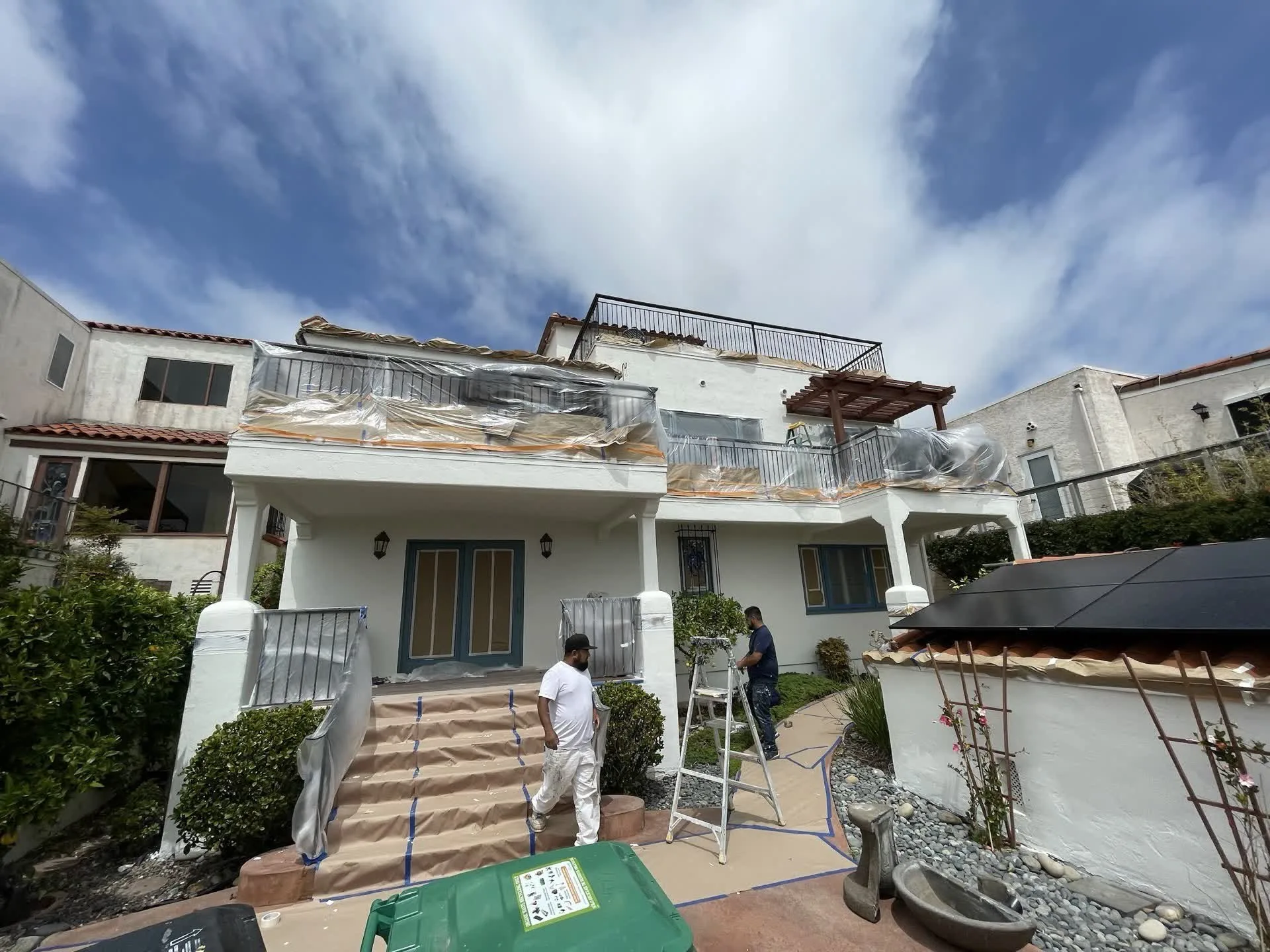 luxury white modern house architecture with lush palm trees and swimming pool in bright california daylight