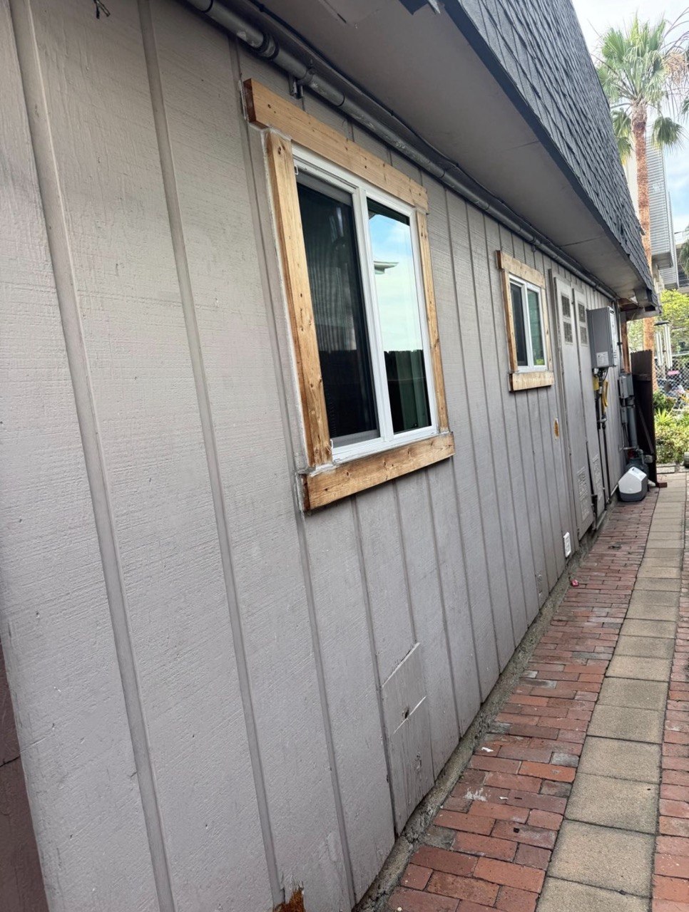 Before: raw wood repairs and unpainted deteriorated siding